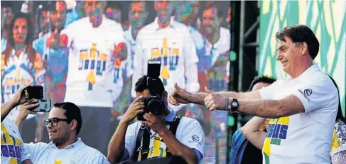  ?? FOTO: AP/EFE ?? > Jair Bolsonaro, presidente de Brasil, saluda con los pulgares hacia arriba a creyentes evangélico­s.