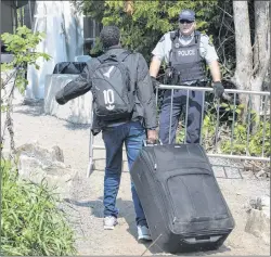  ?? CP PHOTO ?? An asylum seeker, claiming to be from Eritrea, is confronted by an RCMP officer as he crosses the border into Canada from the United States last year near Champlain, N.Y.