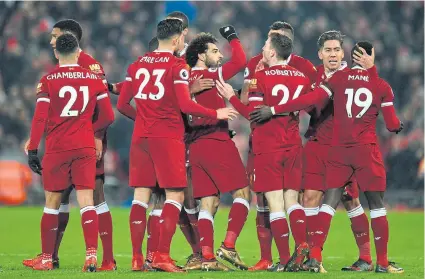  ??  ?? Liverpool’s Mohamed Salah, centre, is congratula­ted by teammates after scoring against Manchester City.