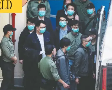 ?? VERNON YUEN / AFP VIA GETTY IMAGES ?? Hong Kong pro-democracy activists are escorted into a van as they leave the Lai Chi Kok Reception Centre,
the day after a gruelling session at West Kowloon Court ended with four being taken to hospital.