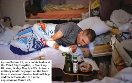  ?? ?? Anton Gladun, 22, eats on his bed in at the Third City Hospital, in Cherkasy, Ukraine, Friday, May 6, 2022. Anton, a military medic deployed on the front lines in eastern Ukraine, lost both legs and the left arm due to a mine explosion on March 27.