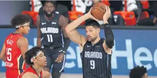  ?? KIM KLEMENT/AP ?? Orlando Magic center Nikola Vucevic (9) controls the ball under pressure from New Orleans Pelicans center Jaxson Hayes, front left, Thursday at ESPN Wide World of Sports.