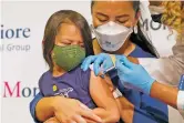  ?? MARY ALTAFFER ASSOCIATED PRESS FILE PHOTO ?? Maria Assisi holds her daughter Mia, 4, as registered nurse Margie Rodriguez administer­s a dose of the Moderna COVID-19 vaccine for children in June at Montefiore Medical Group in the Bronx borough of New York City.