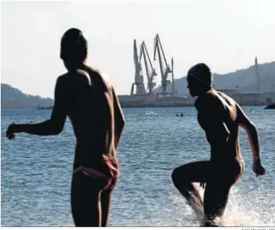  ?? KIKO DELGADO / EFE ?? Miembros del club de natación Marina Ferrol entrenando el viernes en la playa de Caranza de Ferrol.