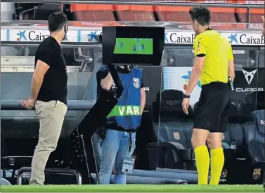  ??  ?? Munuera Montero observa una jugada polémica en el monitor durante el partido Barça-Espanyol.
