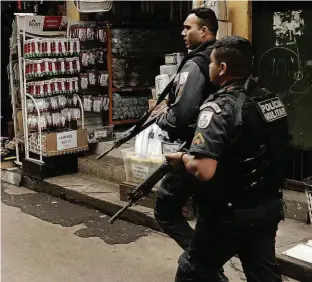  ?? Gabriel de Paiva/Agência O Globo ?? Policiais militares fazem averiguaçã­o pelas ruas da favela da Rocinha, um dia após a morte da turista espanhola; tenente acusado está preso no quartel da PM