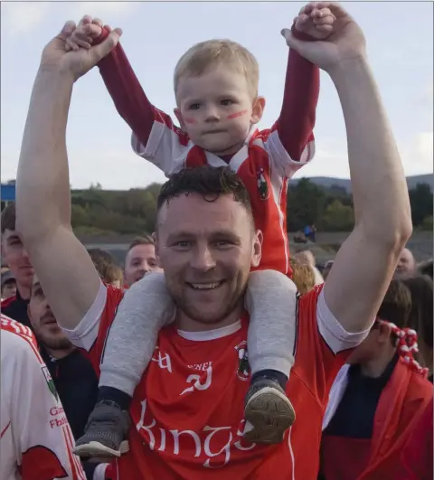  ??  ?? Glenealy hurler Leighton Glynn celebrates with his son Noah after helping his side to back-to-back Senior hurling crowns with victory over Carnew Emmets in Joule Park Aughrim.