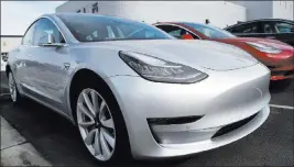  ?? David Zalubowski ?? The Associated Press A Tesla 2018 Model 3 Long Range sits on a dealer’s lot in the south Denver suburb of Littleton, Colo. Long emergency stopping distances, difficult-to-use controls and a harsh ride stopped the electric car from getting a recommende­d...