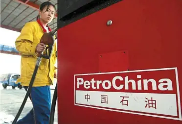  ?? — AFP ?? On an uptrend: a Petrochina petrol station attendant in beijing returns the nozzle at the pumps. after two consecutiv­e years of decline, China’s crude oil imports rapidly rebounded last year, reaching 564 million tonnes, up 11% year-on-year.