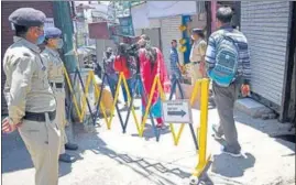  ?? DEEPAK SANSTA/HT ?? Cops standing guard at the entry of Sabzi Mandi during curfew relaxation hours in Shimla on Saturday.