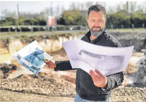  ?? FOTO: STEPHAN KÖHLEN ?? Stefan Göttling schaut sich auf dem Grundstück an der Otto-Hahn-Straße die Baupläne des neuen Gewerbepar­ks an.