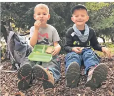  ??  ?? Elion (4) und Noah (4) machen Pause im Wald und genießen ihr Frühstück auf einem Hügel.