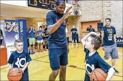  ?? PROCAMP ?? Kevin Durant of the Golden State Warriors gives a high-five to Braeden Randall, 8, of Hutto, after Braeden won the ball-handling title at Durant’s Youth Fantasy ProCamp last month at UT’s Gregory Gymnasium.