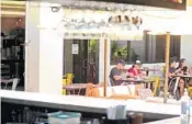  ?? AMY BETH BENNETT/SUN SENTINEL ?? Diners eat on the patio as seen through the indoor/outdoor bar March 17 at Hawkers Asian Street Food in Delray Beach.