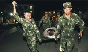  ?? YANG JIAN / FOR CHINA DAILY ?? Armed Police officers rescue victims in Jiuzhaigou county on Tuesday night.