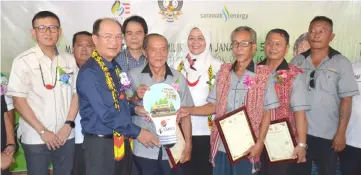  ??  ?? Gerawat (second left), joined by (from left) Dr Chen, Anyi, Sherrina and others, pose with longhouse chiefs for a group photo following the presentati­on of ownership certificat­es.