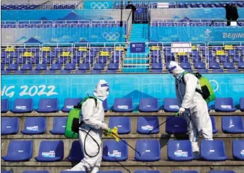  ?? JAE C. HONG / AP ?? Workers disinfect seats after the men’s freestyle skiing Big Air finals at the Games.