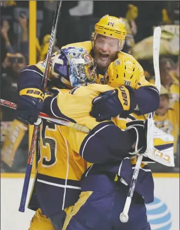  ?? The Associated Press ?? NASHVILLE CATS: Nashville defenseman Mattias Ekholm jumps on goalie Pekka Rinne (35) and left wing Viktor Arvidsson (38) after the Predators beat the Anaheim Ducks 6-3 Monday night to clinch the NHL Western Conference title.