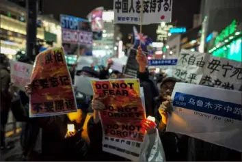  ?? AFP via Getty Images ?? Chinese residents in Tokyo and supporters stage a rally to protest against China’s“zeroCOVID” policy and the dictatoria­l rule of the Chinese Communist Party on Wednesday as part of a candleligh­t vigil for victims of a deadly Nov. 24 fire in western China.