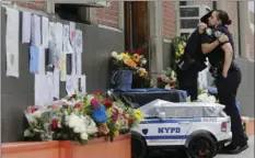  ?? PHOTO/SETH WENIG ?? Police officers hug in front of the 46th Precinct in the Bronx borough of New York on Thursday. AP