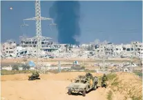  ?? ARIEL SCHALIT/AP ?? Israeli soldiers take up positions near the Gaza Strip border, as smoke rises following an Israeli airstrike in the Gaza Strip on Dec. 29.