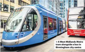  ??  ?? > A West Midlands Metro tram alongside a bus in Birmingham city centre