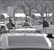  ?? JOHN MCCALL /SOUTH FLORIDA SUN-SENTINEL VIA AP ?? IN THIS FEB. 14 FILE PHOTO, students run with their hands in the air after a shooting at Marjory Stoneman Douglas High School in Parkland, Fla.