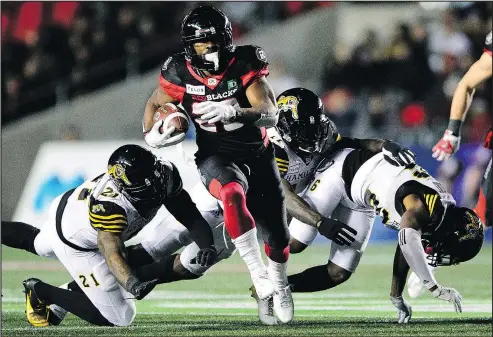  ?? — THE CANADIAN PRESS FILES ?? Redblacks running back William Powell (centre) carries the ball against the Tiger-Cats last week. Ottawa (9-7) can cement top spot in the East with a road win over Hamilton (8-8) on Saturday.