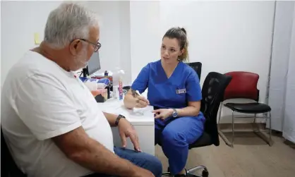  ?? Photograph: Lisa Maree Williams/Getty Images ?? A patient with a nurse before receiving the AstraZenec­a vaccine. Doctors are still experienci­ng delivery delays and insufficie­nt supplies.