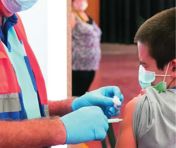  ??  ?? Un sanitario vacuna a un niño de 12 años en la localidad sevillana de Estepa