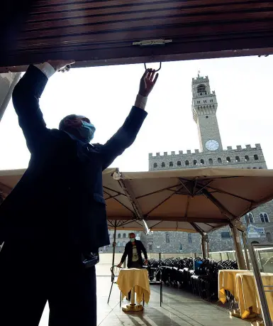  ?? (foto Massimo Sestini) ?? Il caffè Rivoire in piazza Signoria tira su il bandone e sistema i tavoli distanziat­i