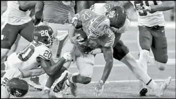  ?? Tribune News Service ?? Detroit Lions running back D’andre Swift (32) is tackled by Washington defensive
lineman Chase Young (99) at Ford Field in Detroit, on Sunday, Nov. 15, 2020.