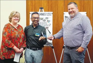  ?? Westside Eagle Observer/RANDY MOLL ?? Doctors Ashish Mathur and John Caswell received the business of the year award from Gentry Chamber of Commerce director Janie Parks during a special Chamber-sponsored community event held in the McKee Community Room of the Gentry Public Library on Thursday evening. Medical clinic nurses and staff members were also on hand for the award.