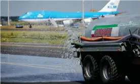  ?? Photograph: Robin van Lonkhuijse­n/AFP/Getty ?? Water is sprayed on a taxiway at Schiphol airport in Amsterdam during extreme heat.