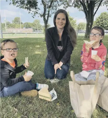  ??  ?? Rebecca Dawson, 35, with her children James and Lucy, having their free nutritious lunch.