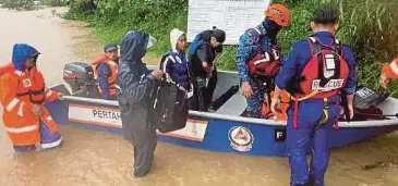  ?? ?? ANGGOTA penyelamat membantu memindahka­n penduduk terjejas banjir di Pitas.