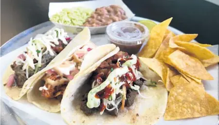  ?? PHILLIP VALYS/SUN SENTINEL ?? The tree-taco combo plate—guajillo chicken, spicy citrus pork and carne asada—at Los Bocados in Parkland.