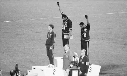  ?? Photograph: Bettmann/Bettmann Archive ?? Tommie Smith (centre) and John Carlos make the salute at the 1968 Olympic Games.