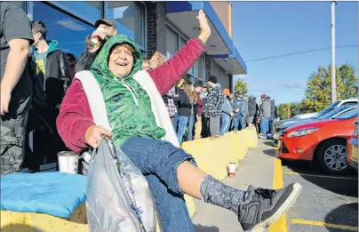  ?? SHARON MONTGOMERY-DUPE-CAPE BRETON POST ?? Carol Anne Steeves, 54, of Ashby, waits in line for the historic opening of the NSLC outlet in Sydney River with the sale of cannabis products, decked out in a sweatshirt and socks depicting marijuana. Steeves said she purchased the clothing at Spencer’s at the Mayflower Mall a while ago but saved it to wear Wednesday. Steeves said Wednesday was “a good historic day to celebrate. “