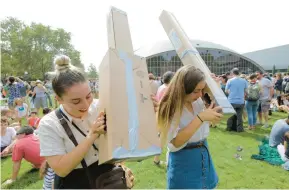  ?? STEVEN SENNE/AP 2017 ?? Reveka Pasternak, left, and her sister, Tristen, use pinhole projectors to view a partial solar eclipse on the campus of the Massachuse­tts Institute of Technology in Cambridge.