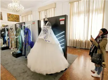  ?? — AFP photo ?? A visitor looks at creations displayed during the annual exhibition on fashion and clothes designed by young Iranian designers, at the Sadabad Palace Complex, north of the Iranian capital Tehran.