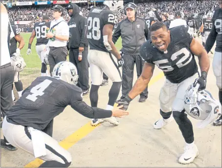  ?? STAFF ARCHIVES ?? Derek Carr and Khalil Mack, who joined the team in the same year, celebrate in happier times with the Raiders.