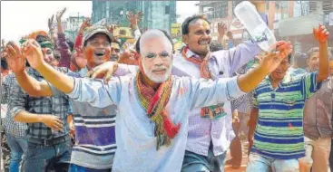  ?? PTI PHOTO ?? A BJP supporter wears a mask of Prime Minister Narendra Modi to celebrate the party's victory in Agartala on Saturday.
