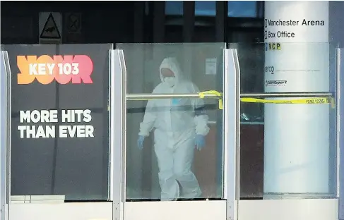  ?? DANNY LAWSON / PA VIA AP ?? A forensic investigat­or walks along a bridge linking Victoria Station with the Manchester Arena on Tuesday as police continue to search for clues.