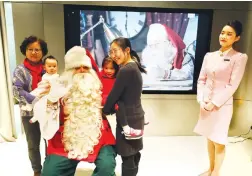  ??  ?? People pose for photo with Santa Claus at a Finnish tourism event held on Monday in Shanghai.