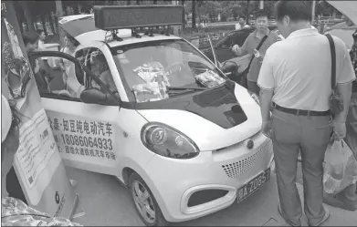  ?? ZHOU GUOQIANG / FOR CHINA DAILY ?? An electric vehicle, made by Zhidou Electric Vehicle Sales Co Ltd, attracts attention from car buyers during an EV sales promotion event in Wuhan, Hubei province.