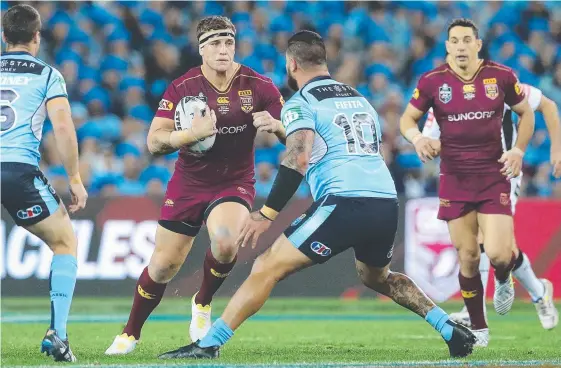  ?? Picture: PETER WALLIS ?? Queensland’s Jarrod Wallace runs into the NSW defence during Origin II.