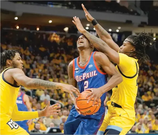  ?? AP ?? DePaul guard Umoja Gibson drives to the basket between two Marquette defenders Saturday in Milwaukee. He scored 20 points in the Blue Demons’ loss.