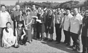  ??  ?? Bong hands over a cheque for the amount to Dennis while others look on.