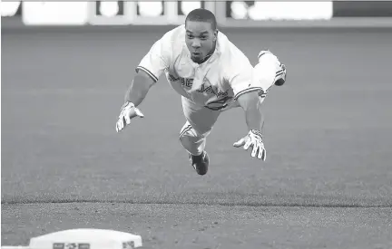  ?? TOM SZCZERBOWS­KI/GETTY IMAGES ?? Ben Revere of the Toronto Blue Jays slides safely into third base as he advances on a throwing error following his single in the fifth inning during action against the Minnesota Twins on Thursday at Rogers Centre in Toronto. The Jays swept the series...